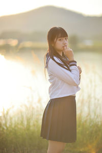 Portrait of young woman standing on field