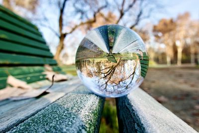 Close-up of crystal ball against sky