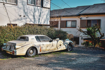 Vintage car on road by buildings in city