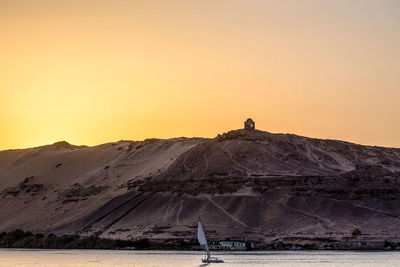 Scenic view of land against clear sky during sunset