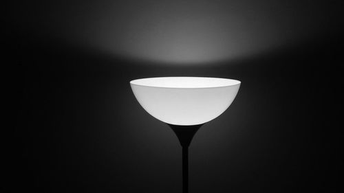 Low angle view of illuminated lamp against black background