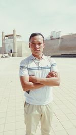 Young man standing against sky in city