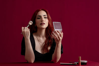 Young woman using mobile phone while sitting on table