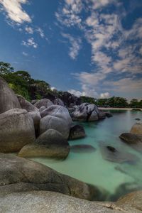 Rocks by sea against sky