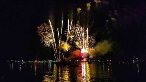 Firework display over river at night