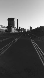 Railroad tracks in city against clear sky