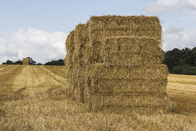 Hay bales on field against sky