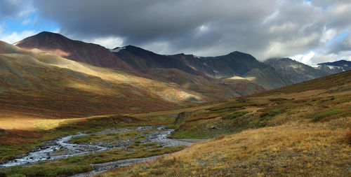 Scenic view of mountains against cloudy sky