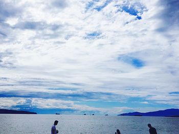 People on beach against sky