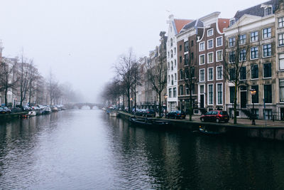 Boats in canal along buildings