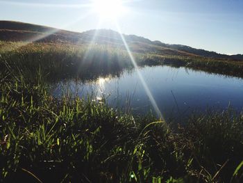 Scenic view of lake against sky on sunny day