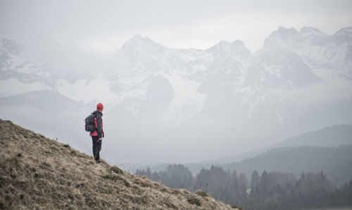 Man standing on mountain road during foggy weather