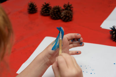 Cropped image of girl painting finger