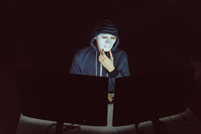 Portrait of a young man sitting in the dark