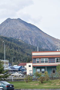 Houses by mountains against sky in city