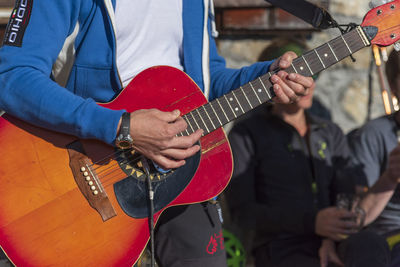 Midsection of man playing guitar