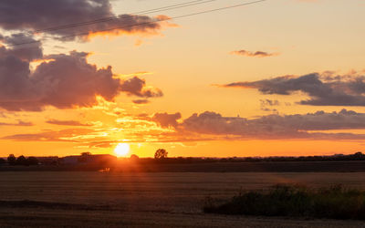 Scenic view of silhouette field against sky during sunset