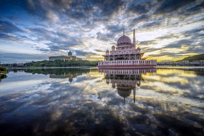 Reflection of putra mosque on lake against cloudy sky