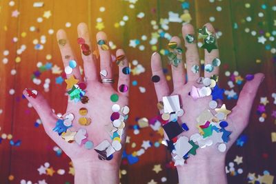 Cropped hands of woman with colorful confetti