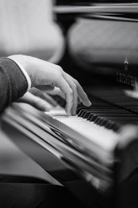 Cropped hand of man playing piano