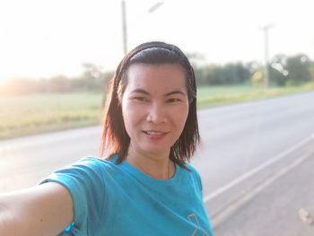 Portrait of smiling mature woman standing on road