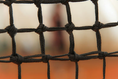 Close-up of rope tied to metal fence