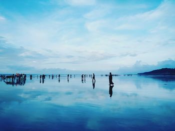 People enjoying in sea against sky