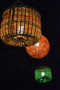 Low angle view of illuminated lantern hanging against black background