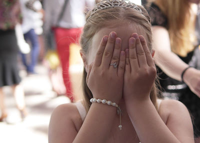 Girl covering face in city