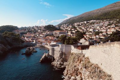 High angle view of townscape by sea against sky