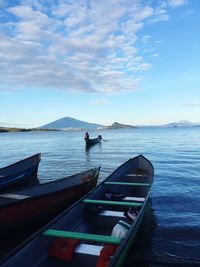 People traveling in boat on sea against sky