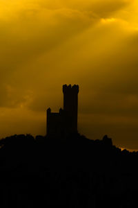 Silhouette building against sky during sunset