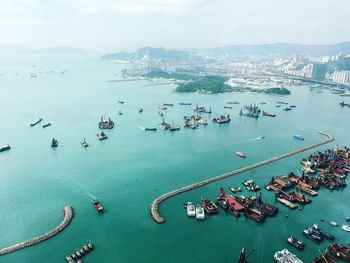 Aerial view of boats in sea at harbor against sky