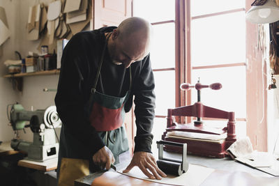 Man cutting textile in atelier