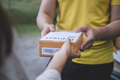 Midsection of man holding text on paper