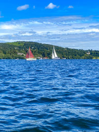 Sailboat sailing in sea against sky