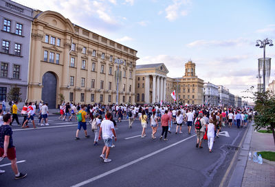 People on street against buildings in city