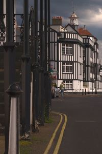 Rear view of man walking on road by buildings