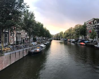 Canal amidst buildings in city against sky