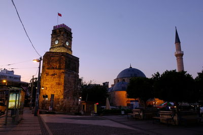 Buildings in city against clear sky at dusk