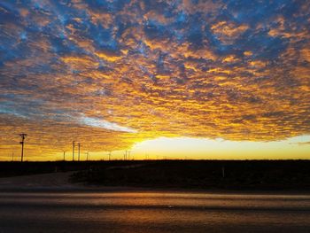 Scenic view of silhouette landscape against orange sky