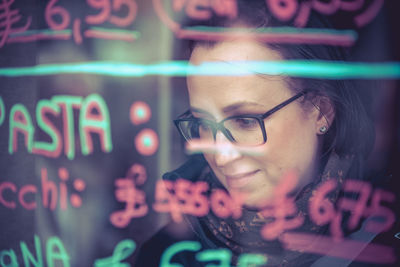 Close-up of woman seen through glass