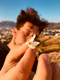 Close-up portrait of man holding flower