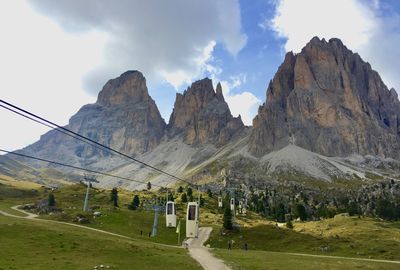 Panoramic view of landscape and mountains with cable car against sky