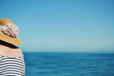 Close-up of woman standing by sea against clear sky