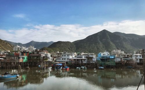 Reflection of houses in lake against sky