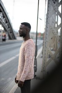 Young man looking away in city