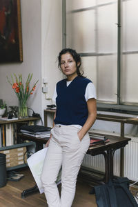 Portrait of businesswoman with hand in pocket standing at home office