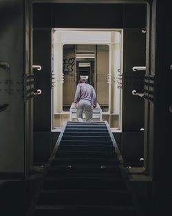 Rear view of man walking in ship corridor