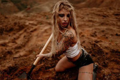 Young girl digs sand with a shovel